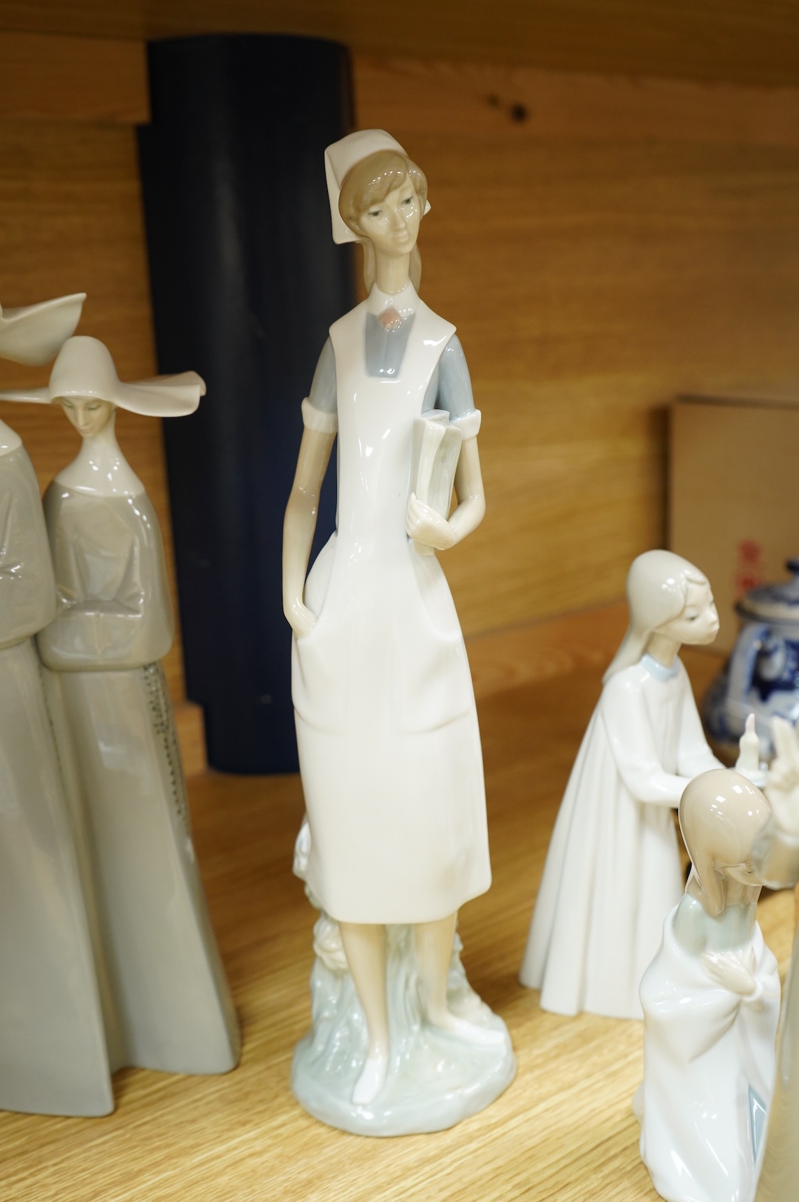 A group of Lladro figures - two Nuns, Geisha, Priest, Virgin Mary, Orange Girl with candle, Girl praying (8) tallest Nuns 33cm high